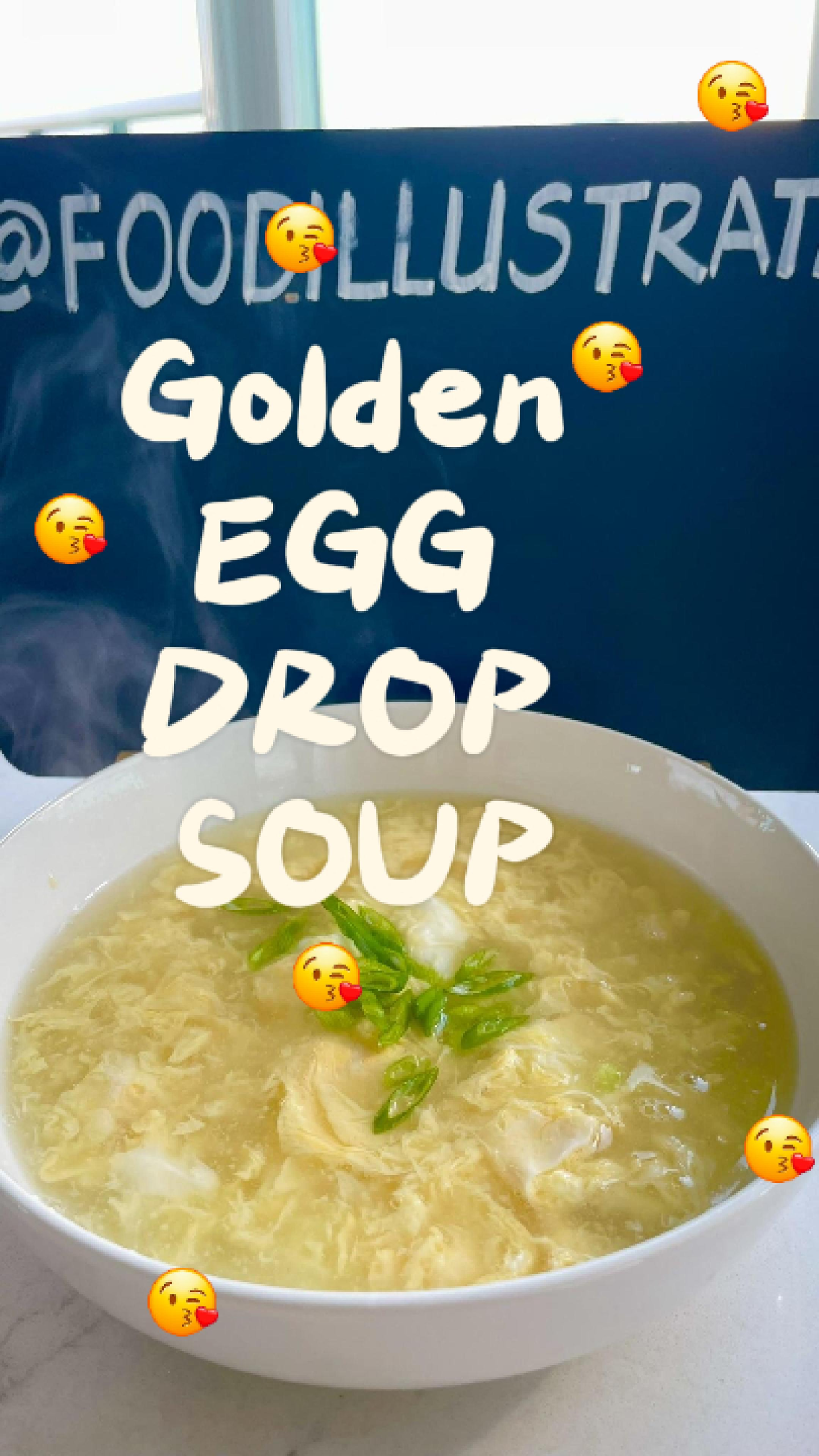 A steaming white bowl of golden egg drop soup garnished with fresh green onions, showcasing delicate silky egg ribbons floating in a rich, turmeric-infused broth.