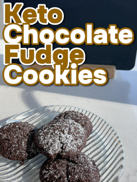 A stack of rich, fudgy keto chocolate fudge cookies on a rustic wooden board with visible cracks and chocolate texture
