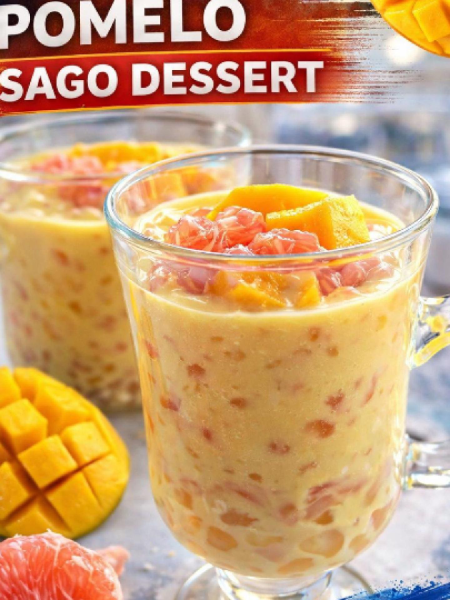 A chilled glass bowl of mango pomelo sago, the classic Hong Kong dessert, featuring vibrant yellow mango puree, chewy tapioca pearls, juicy red pomelo segments, and fresh mint garnish.