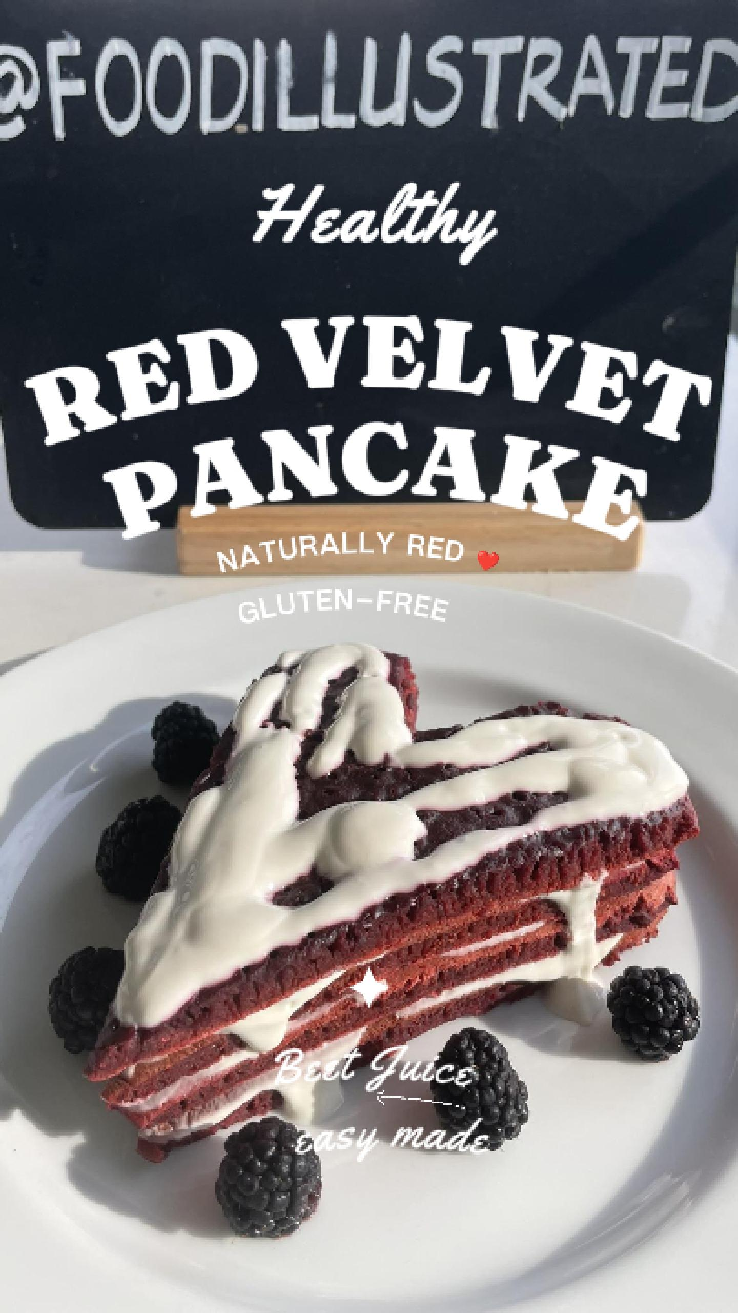 A tall stack of healthy red velvet pancakes cut into a perfect heart shape, topped with white cream cheese drizzle and fresh raspberries