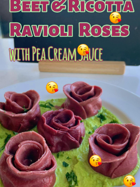 homemade Beet Ricotta Ravioli Roses plated on a vibrant green pea cream sauce, finished with grated Parmesan cheese.